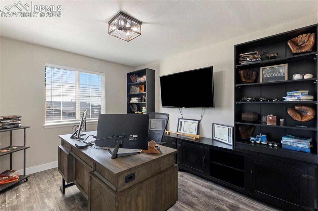 7636 Bullet Road Peyton, CO 80831 - Photo 17 of 30 a view of a workspace with furniture and a flat screen tv