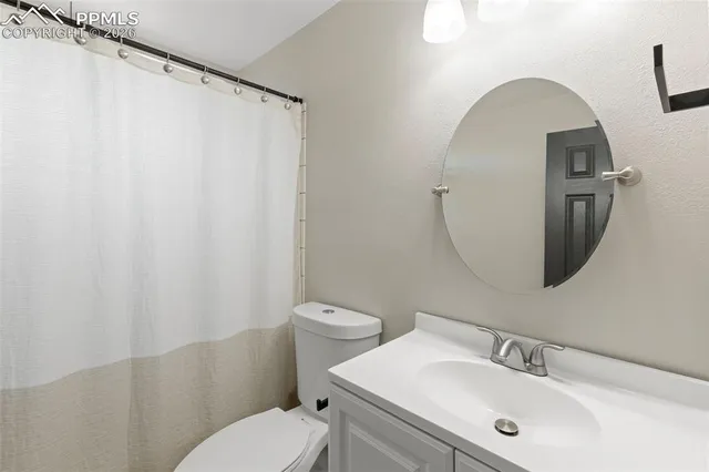 a bathroom with a sink mirror and toilet