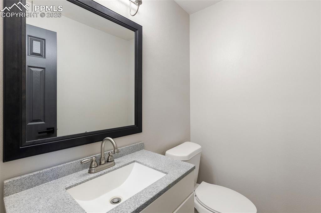 7636 Bullet Road Peyton, CO 80831 - Photo 20 of 30 a bathroom with a toilet a sink and mirror