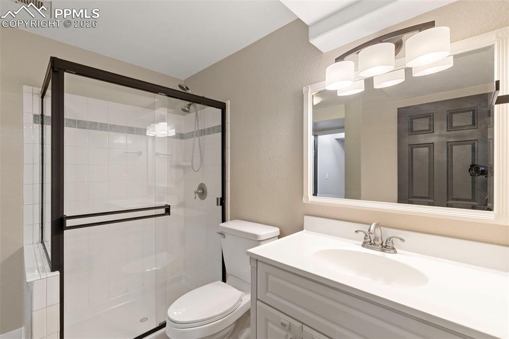 7636 Bullet Road Peyton, CO 80831 - Photo 23 of 30 a bathroom with a sink a mirror a toilet and shower
