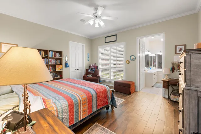a bedroom with a bed a large window and book shelf