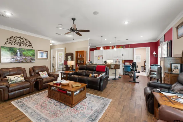 a living room with furniture kitchen view and a large window