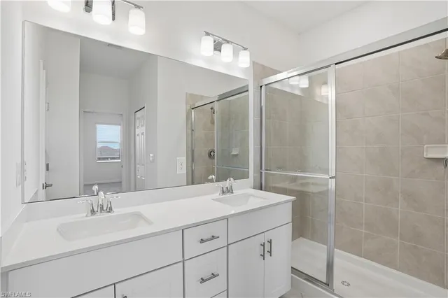 a bathroom with double vanity sink and a mirror
