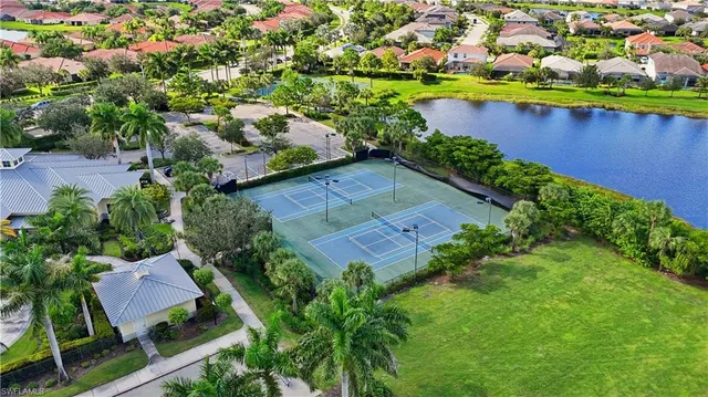 an aerial view of residential houses with outdoor space and trees