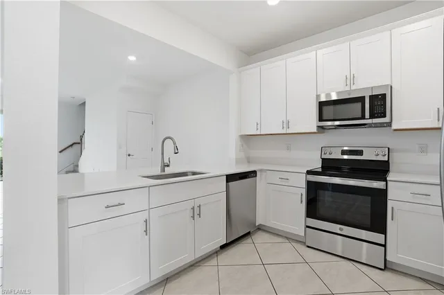 a kitchen with white cabinets stainless steel appliances and sink
