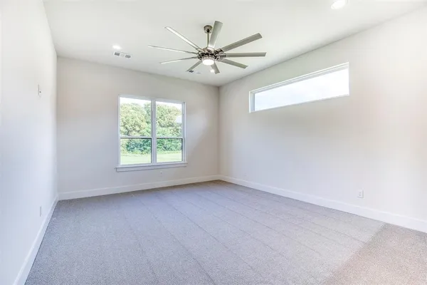 an empty room with a window and a fan