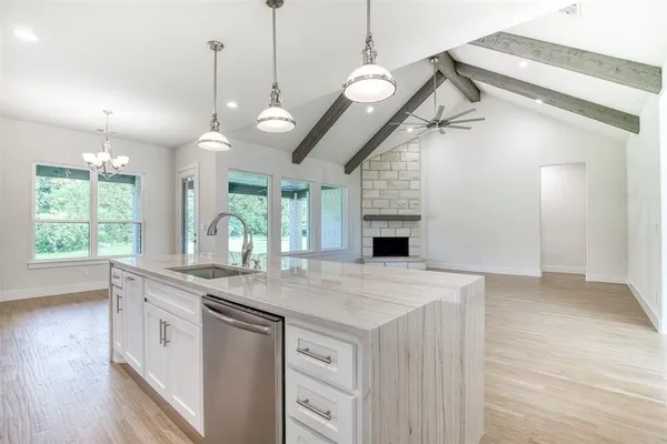 a kitchen with a stove a sink a window and wooden floor
