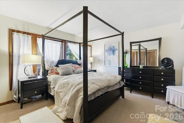 a bedroom with a bed window and dresser