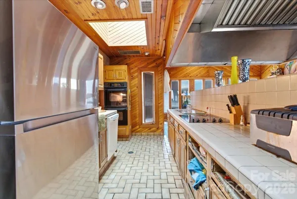 a kitchen with stainless steel appliances granite countertop a refrigerator a stove and a sink