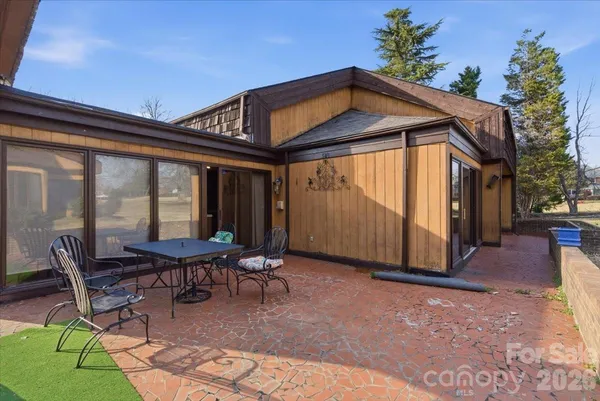 a patio with a table and chairs and potted plants