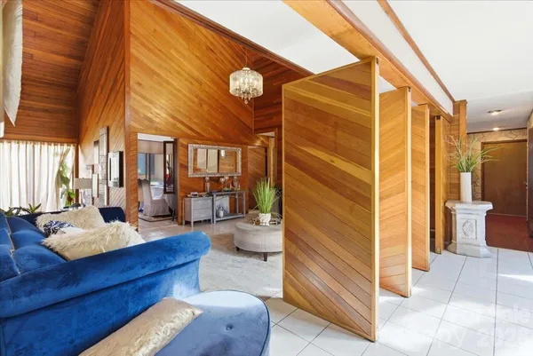 a living room with furniture and a painting on the wall