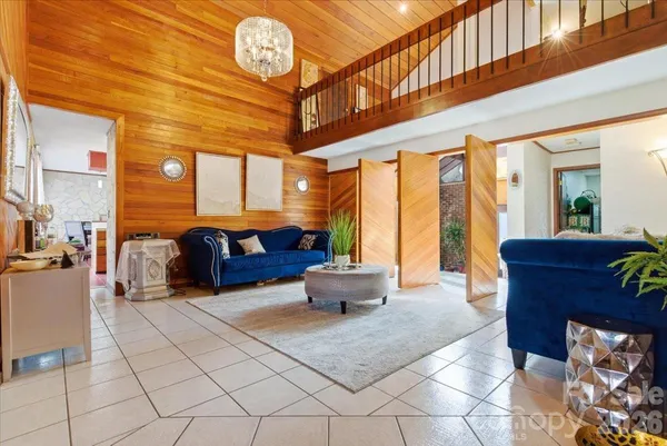 a living room with furniture a chandelier and a large window