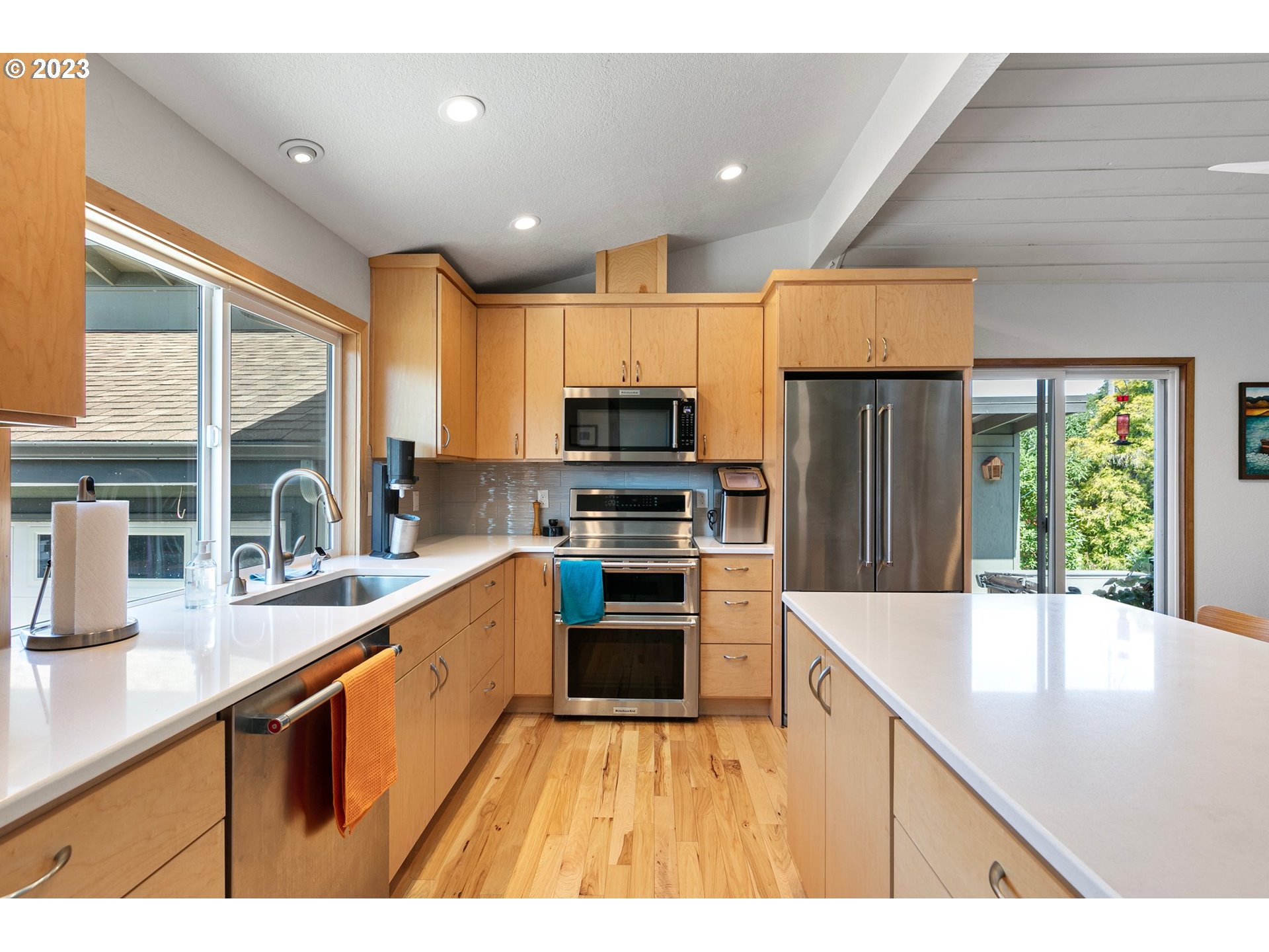2117 7th Street Springfield, OR 97477 - Photo 16 of 48 a kitchen with stainless steel appliances a sink dishwasher a stove top oven a refrigerator with island and chairs