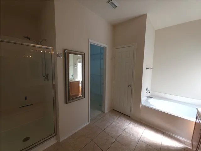 a view of an empty room and chandelier fan