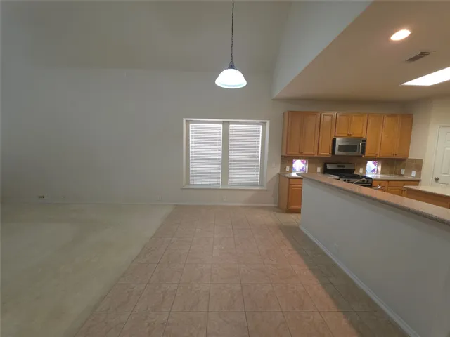 an empty room with a window and a ceiling fan