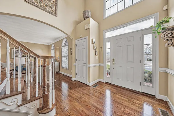 a dining room with furniture a chandelier and wooden floor