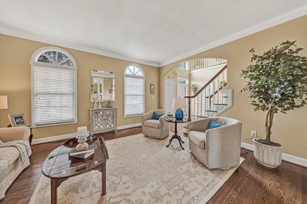 a kitchen with stainless steel appliances granite countertop a refrigerator a sink dishwasher a stove and a dining table with wooden floor