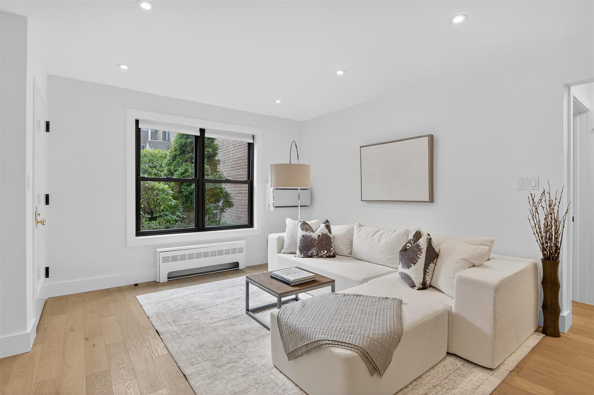 26 Terrace Circle, Unit 9C Great Neck, NY 11021 - Photo 3 of 22 Living room featuring radiator heating unit, light wood finished floors, and recessed lighting