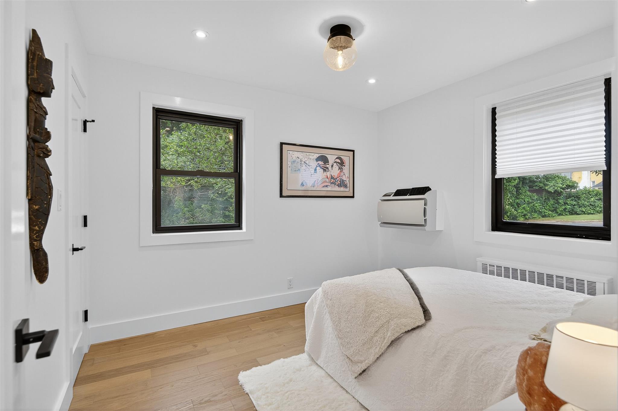 26 Terrace Circle, Unit 9C Great Neck, NY 11021 - Photo 8 of 22 Bedroom featuring radiator, light wood-type flooring, recessed lighting, and heating unit
