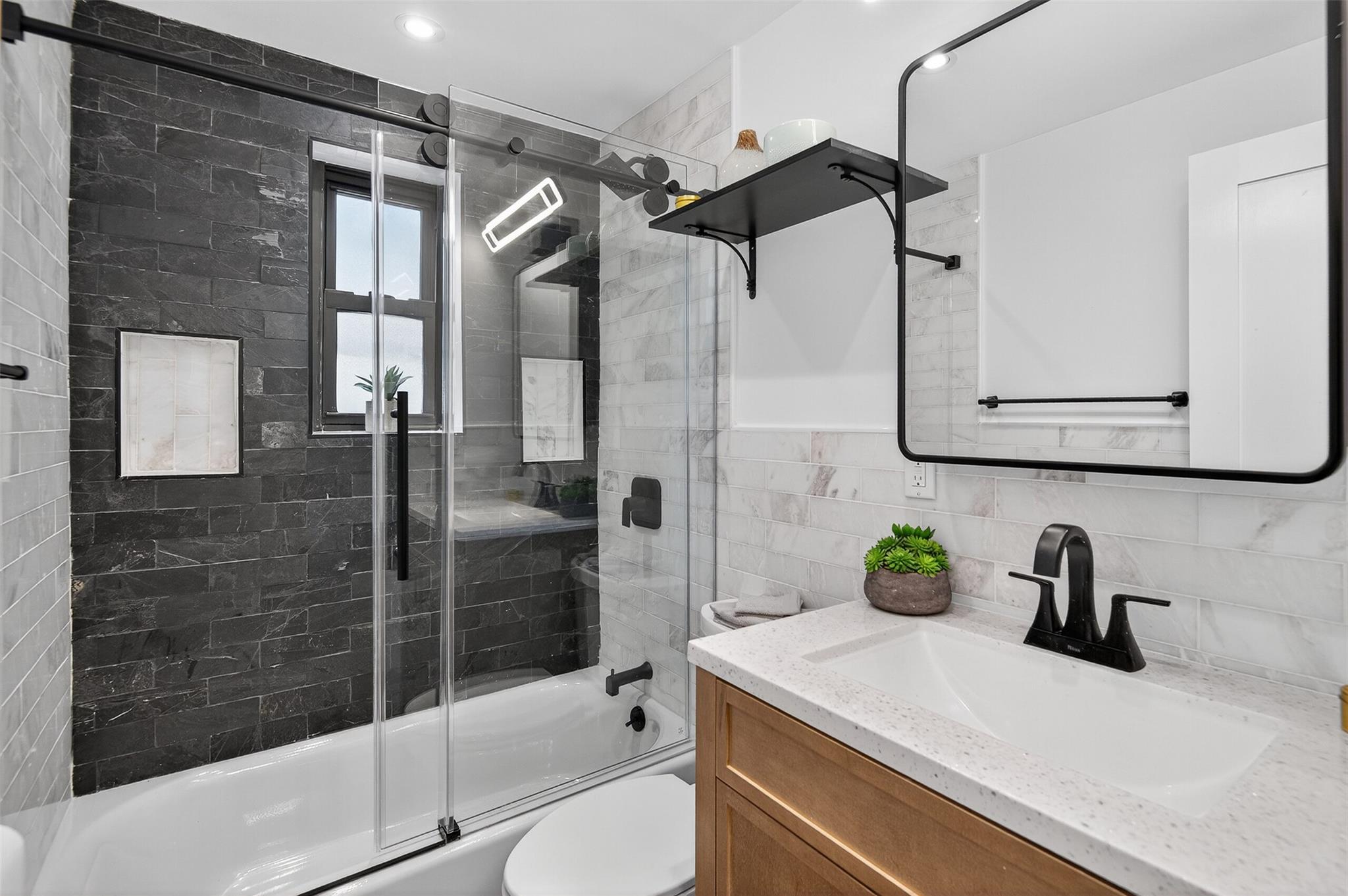 26 Terrace Circle, Unit 9C Great Neck, NY 11021 - Photo 9 of 22 Full bathroom featuring enclosed tub / shower combo, vanity, tile walls, and backsplash