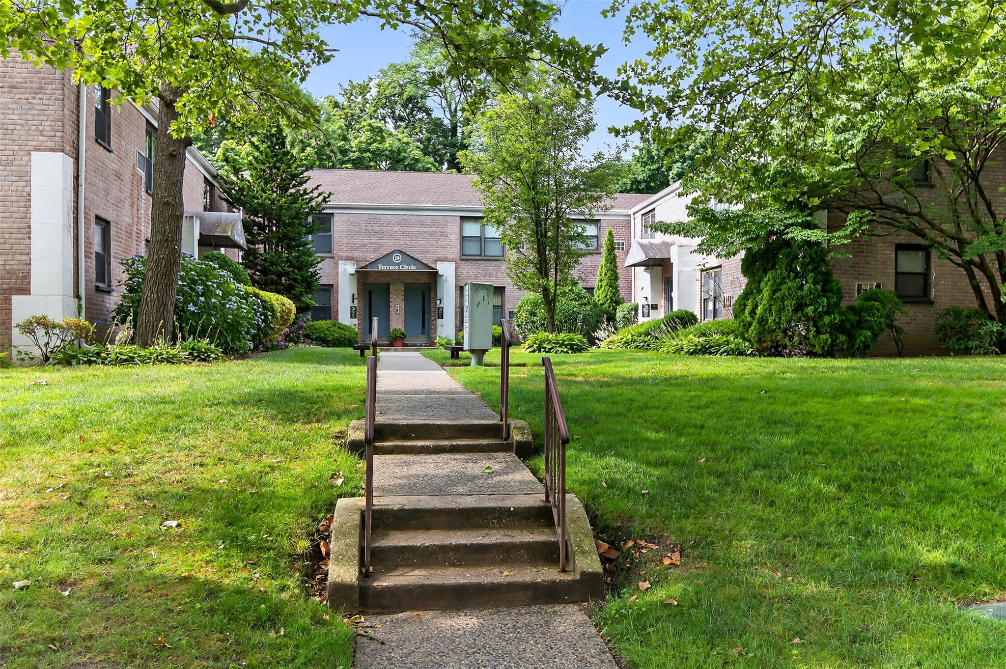 26 Terrace Circle, Unit 9C Great Neck, NY 11021 - Photo 10 of 22 Townhome / multi-family property featuring brick siding, a front lawn, and a residential view