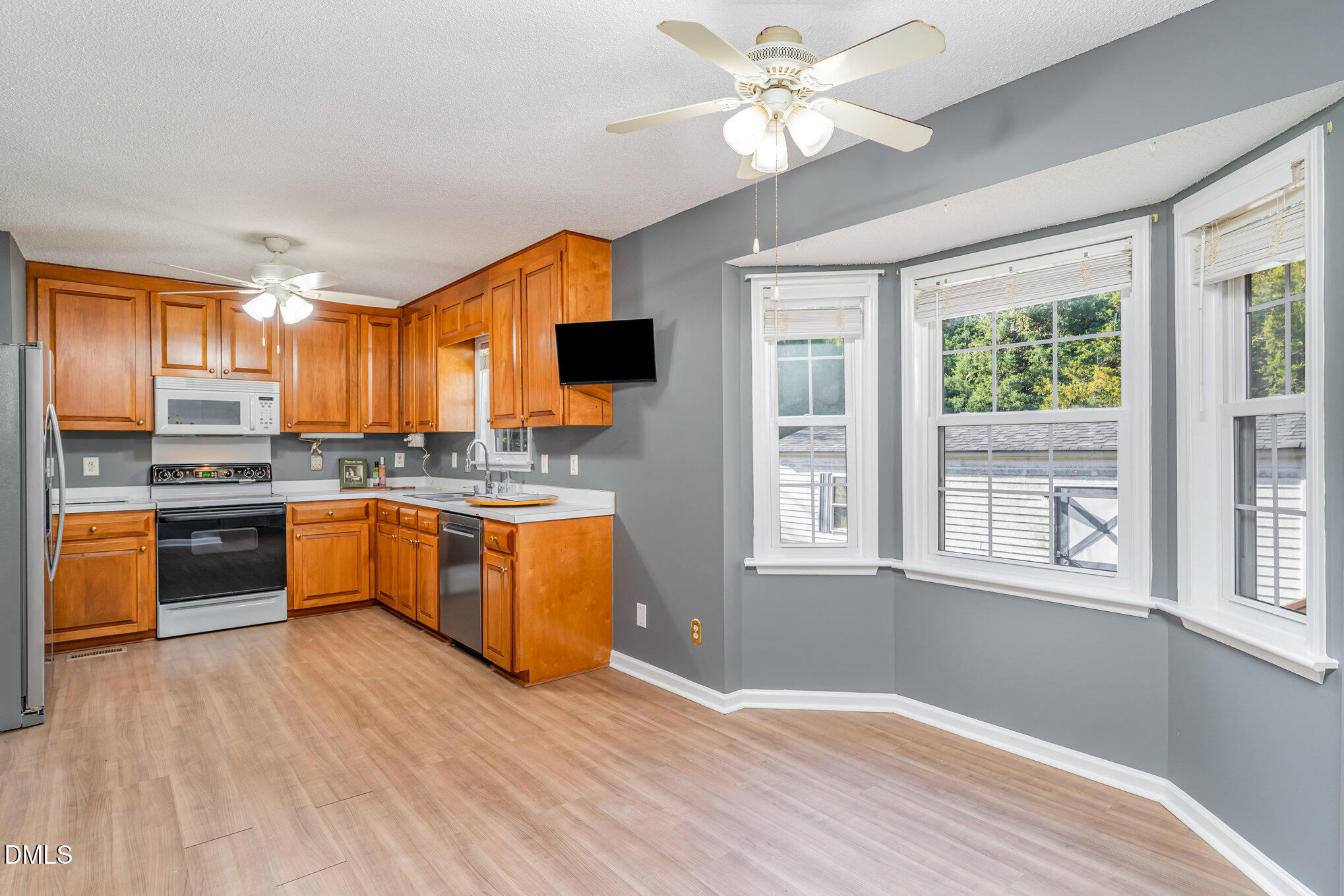 6408 Glen Brack Court Raleigh, NC 27603 - Photo 7 of 23 a kitchen with stainless steel appliances granite countertop a stove top oven a sink dishwasher a dining table and chairs with wooden floor