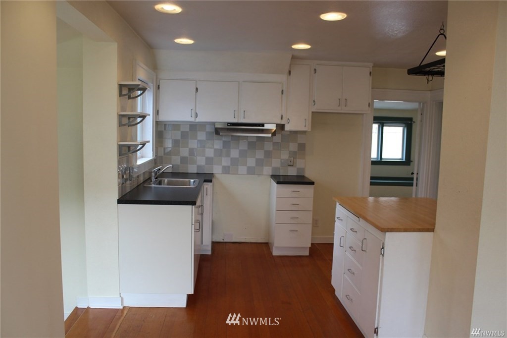 2515 16th Avenue South Seattle, WA 98144 - Photo 12 of 18 a kitchen with white cabinets and sink