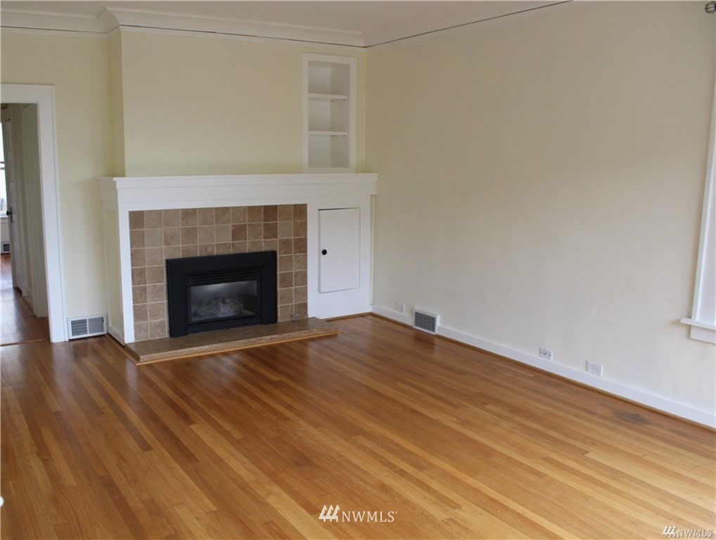 2515 16th Avenue South Seattle, WA 98144 - Photo 4 of 18 a view of empty room with wooden floor and fireplace