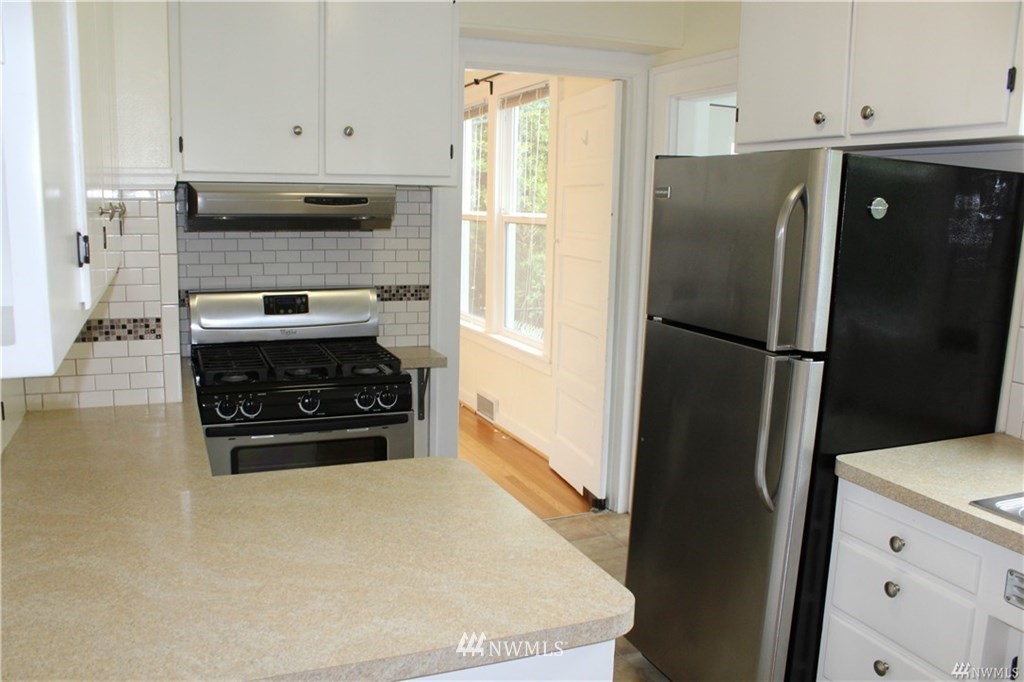 2515 16th Avenue South Seattle, WA 98144 - Photo 5 of 18 a kitchen with stainless steel appliances a refrigerator a stove a sink and a window