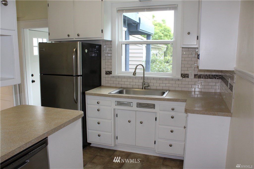 2515 16th Avenue South Seattle, WA 98144 - Photo 6 of 18 a kitchen with granite countertop a sink a refrigerator a stove and a window