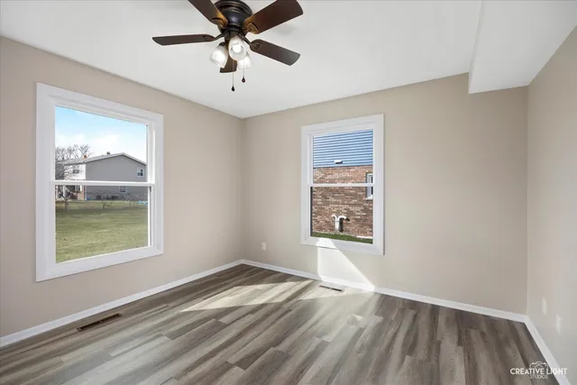 a view of empty room with window and wooden floor