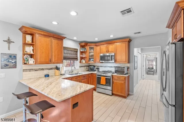 a kitchen with stainless steel appliances granite countertop a sink stove and refrigerator