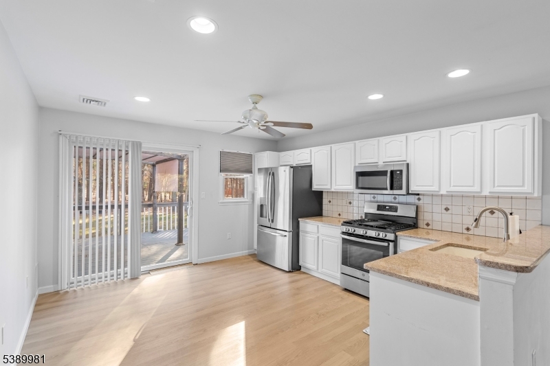 379 East Bird Village Road Jackson, NJ 08527 - Photo 28 of 38 a kitchen with stainless steel appliances granite countertop a stove top oven a sink dishwasher a refrigerator and a microwave