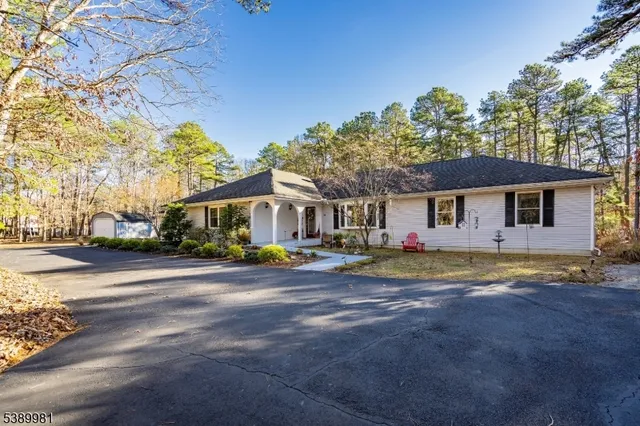 a view of a house with a yard and large trees