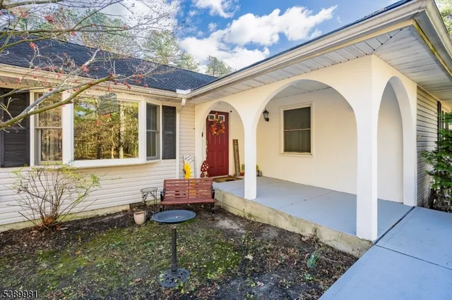 a front view of a house with large windows and a table and chairs