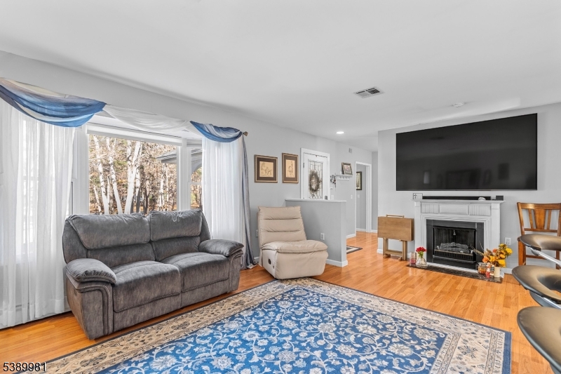 379 East Bird Village Road Jackson, NJ 08527 - Photo 6 of 38 a living room with furniture a flat screen tv and a fireplace