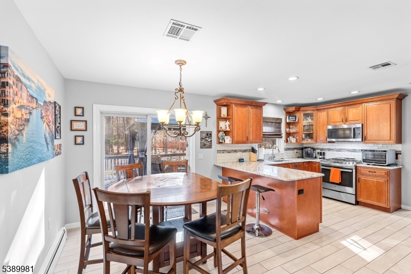 379 East Bird Village Road Jackson, NJ 08527 - Photo 9 of 38 a kitchen with stainless steel appliances a dining table chairs and wooden floor