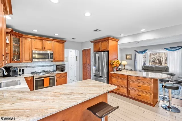 a kitchen with stainless steel appliances granite countertop sink stove and refrigerator