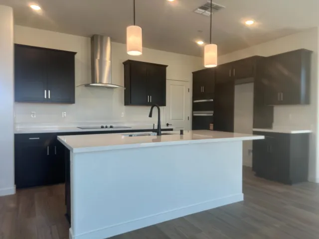 a kitchen with kitchen island a sink stainless steel appliances and a counter top space