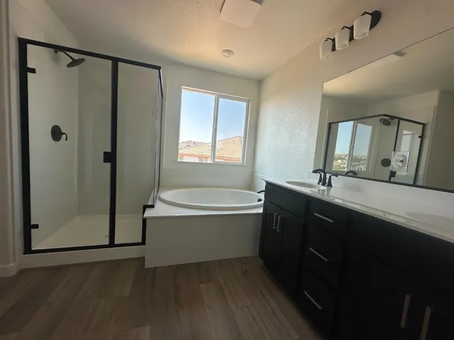 a spacious bathroom with a double vanity sink a mirror and a bathtub