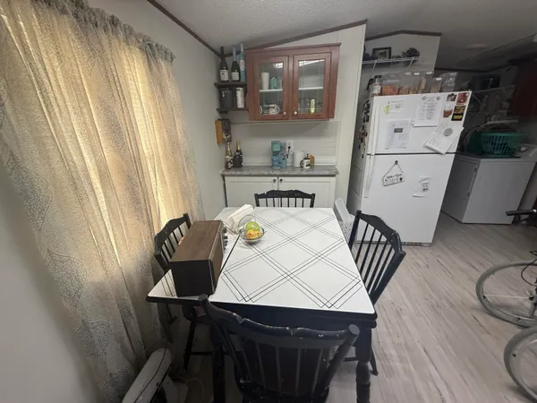 a kitchen with a table chairs and a refrigerator