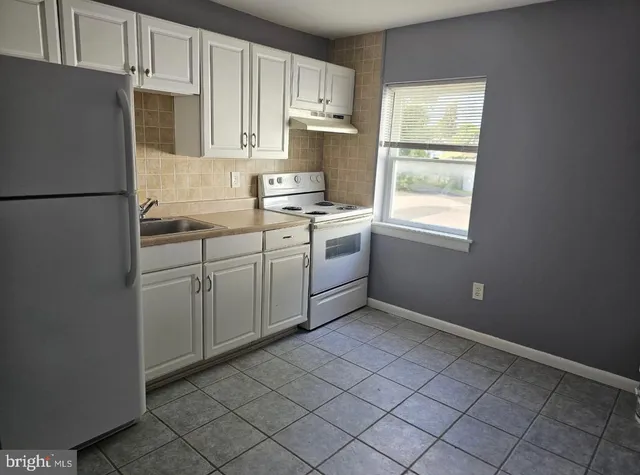 a kitchen with a refrigerator sink and cabinets