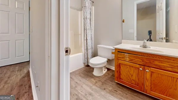 a bathroom with a granite countertop toilet sink and mirror