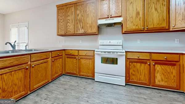 a kitchen with granite countertop wooden cabinets stainless steel appliances and a sink