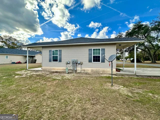 a backyard of a house with table and chairs