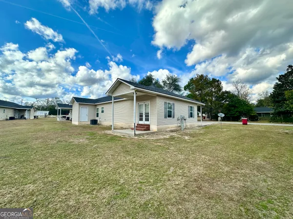 a view of a house with backyard and a tree