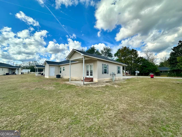 a view of a house with backyard and a tree