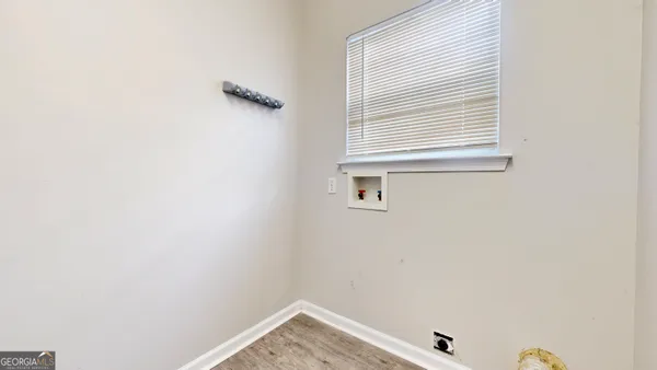 a view of a small space with wooden floor and a window