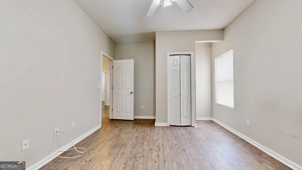 an empty room with wooden floor and windows