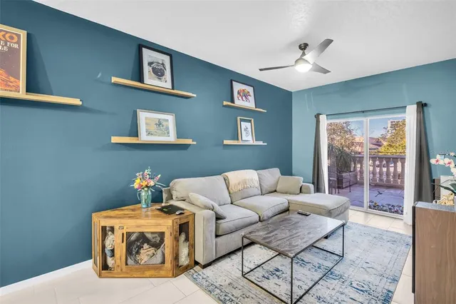 a living room with furniture and a ceiling fan